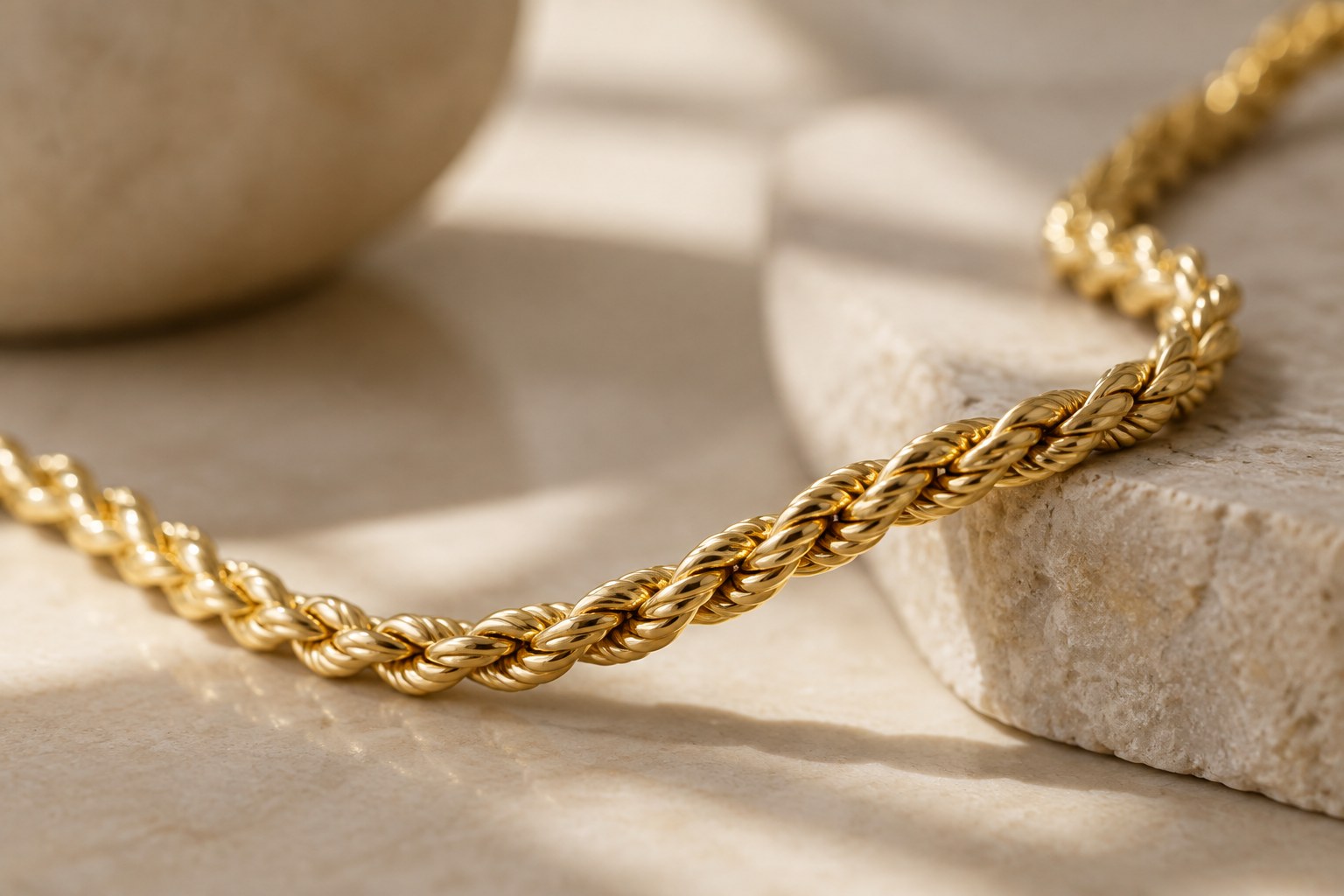 Illustration: macro of a twisted gold rope chain catching soft window light
