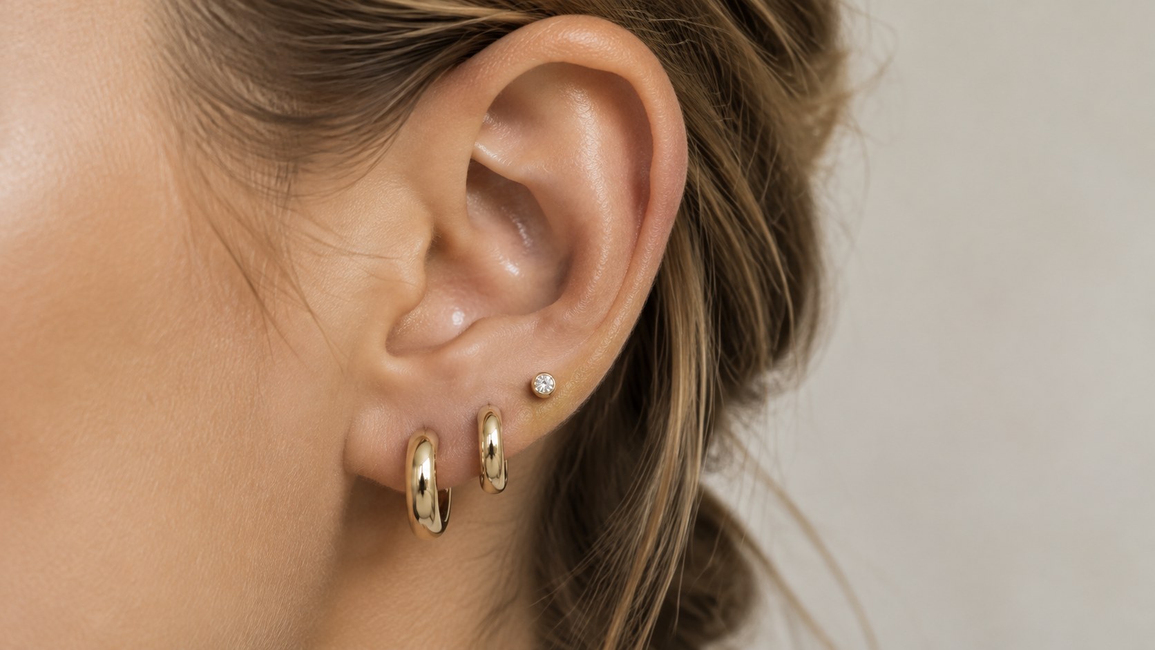 An ear with graduated huggies and a tiny stud
