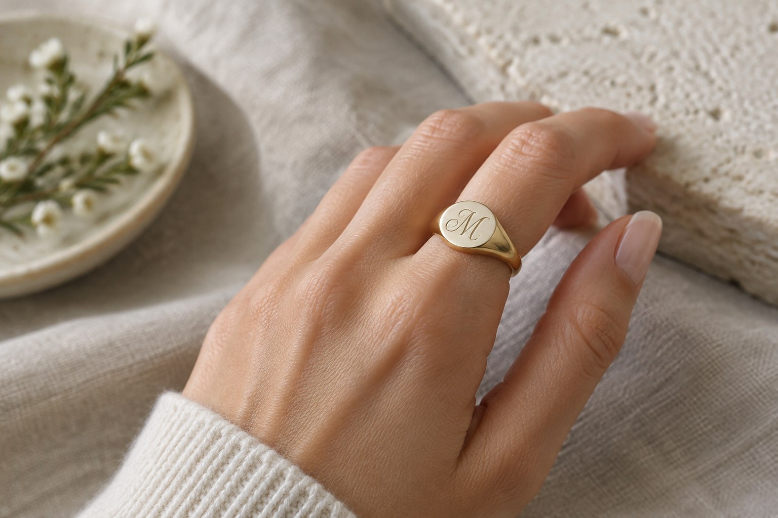 Illustration: a monogrammed signet ring worn on the hand